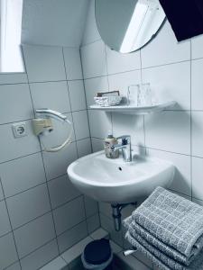 博伊岑堡Hotel Stadt Boizenburg的白色的浴室设有水槽和镜子