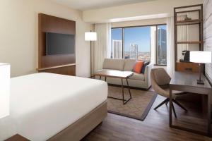 凤凰城凤凰凯悦酒店的酒店客房配有一张床、一张书桌和一台电视。