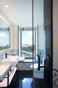班加罗尔班加罗尔MG路凯悦中心酒店的一间带两个盥洗盆和窗户淋浴的浴室