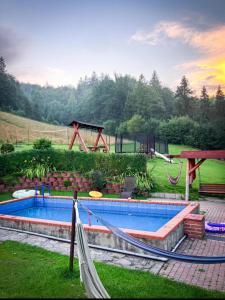 维斯瓦Apartamenty Kadłubek的一个带吊床的游泳池和一个游乐场