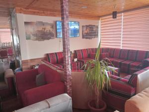 Ma‘āncabin hotel的一间设有红色沙发和植物的等候室