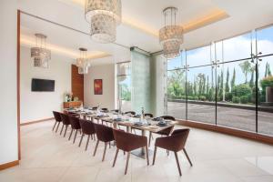 海得拉巴Hyatt Place Hyderabad Banjara Hills的大型用餐室配有长桌和椅子