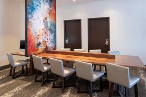 皇家橡Hyatt Place Detroit/Royal Oak的一间会议室,配有木桌和椅子