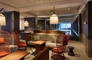 墨尔本Hyatt Centric Melbourne的餐厅设有椅子、沙发和桌子