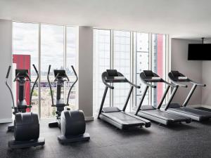 伦敦伦敦假日酒店 - 斯特拉特福市的一个带有氧器材的健身房,位于一个设有大窗户的房间