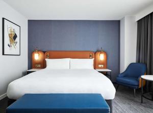 伦敦伦敦假日酒店 - 斯特拉特福市的一间卧室配有一张大床和一张蓝色椅子