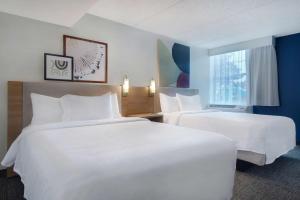 罗切斯特纽约州罗切斯特大学区丽怡酒店的酒店客房设有两张床和窗户。
