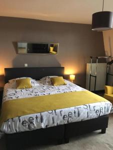 尼乌波特B&B De Kaai的一间卧室配有一张大床和两张黄色枕头
