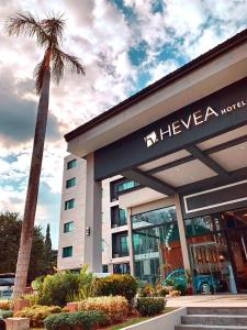 安吉利斯Hevea Hotel & Resort的一座建筑前有棕榈树的酒店