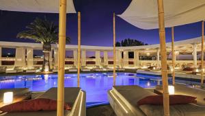 米克诺斯城安德罗尼哥斯酒店的夜间酒店游泳池,带两张床