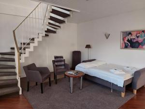 鲁尔河畔米尔海姆弗里克酒店的一间卧室配有一张床,楼梯配有椅子和桌子