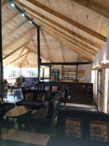 卡拉图Ngorongoro Camp and Lodge的大型客房设有椅子和带横梁的天花板。