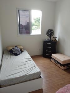 里约热内卢Aconchego Hostel的一间卧室配有一张床、一个梳妆台和一扇窗户。