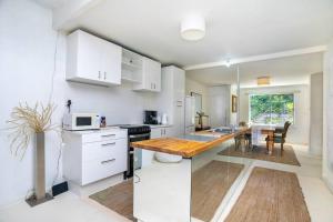 珀斯Vivid house in Wembley Downs的厨房配有白色橱柜和木制台面
