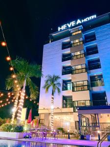 安吉利斯Hevea Hotel & Resort的一座楼前有棕榈树的酒店