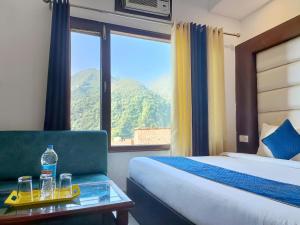 格德拉Hotel Katra Residency的酒店客房配有一张床和一张带水瓶的桌子。
