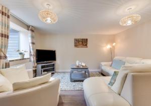 WaldingfieldArdley Cottages的客厅配有白色家具和平面电视