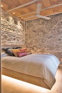科尔多瓦HomeSuiteHome Córdoba的一间卧室配有一张石墙床