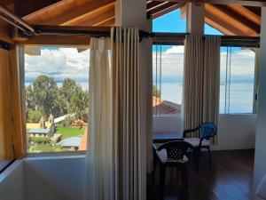 Comunidad YumaniCASA DE LA LUNA-Isla del sol Bolivia的客房设有带桌椅的大窗户。