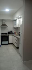 埃塞萨El Descanso的白色的厨房配有炉灶和冰箱。