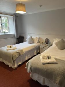 约维尔列王纹章酒店的一间卧室配有两张带毛巾的床