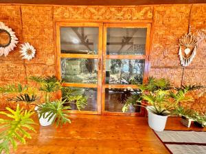 曼巴豪Playa del Fuego Camiguin Beach Hostel & Resort的一间有门和一束植物的房间