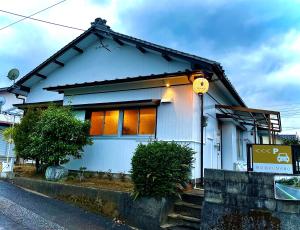 宫崎貸切宿KUMANO的白色房子,街上有橙色窗户