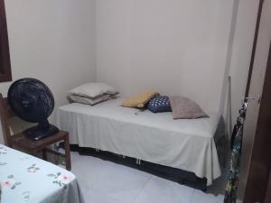 桑塔克鲁茨卡巴利亚Cantinho da Margarete的一张小床,里面配有枕头