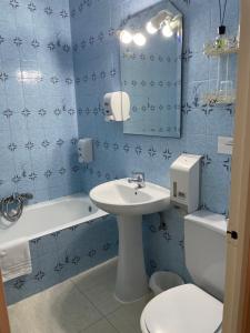 圣阿德里安Hostal Ochoa的蓝色瓷砖浴室设有水槽和卫生间