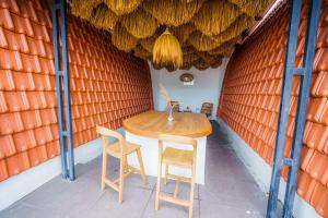 坎古Shortcut Breeze Guest House的橙色墙壁的房间里摆放着桌椅