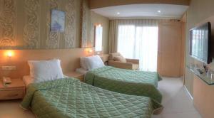 图尔古特雷斯Marin-A Hotel & Spa Turgutreis的酒店客房,设有两张床和一张沙发
