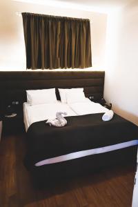 塞克希费黑瓦尔Bory Apartman, zárt udvari parkolás的卧室内的一张带白色床单和枕头的床
