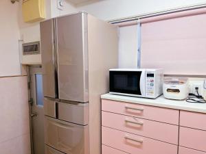 丰中Otami Stay的厨房配有不锈钢冰箱和微波炉。