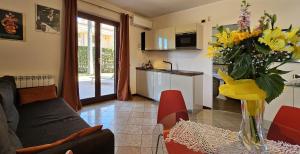 马斯卡利Etna, mare e verde (double room in villa)的客厅配有沙发和黄色花瓶