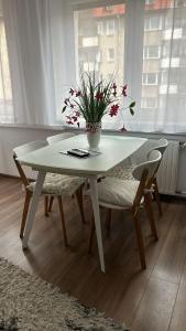 托伦Golden Apartament Legionów的白色的桌椅和花瓶