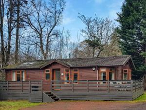 巴洛赫Loch Lomond Sanctuary Lodges的小木屋前方设有围栏