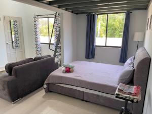 哥打巴鲁Homestay Studio TOKAYOH的一间卧室配有一张床、一张沙发和窗户。