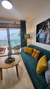 卡尔佩Esmeralda Suites Sunrise的客厅配有绿色沙发和桌子
