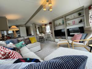 塞顿港Seton Sands Haven Holiday Park - Prestige Caravan的带沙发和电视的客厅