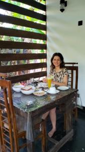 锡吉里亚Yashi's Place Sigiriya的坐在餐桌旁吃饭的女人