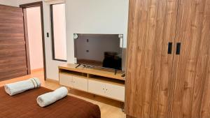 基多Edificio Tofino的一间带电视和大型木制橱柜的卧室