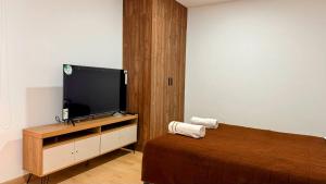 基多Edificio Tofino的一间卧室配有一张床和一台平面电视
