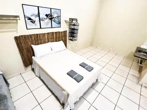 乌贝兰迪亚Loft Familiar BR-Aeroporto 4的白色瓷砖卧室内的一张床