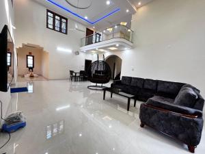 PāngālaUdupi Homestay - Chiradeep Villa的客厅配有黑色沙发和桌子