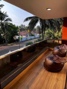 PāngālaUdupi Homestay - Chiradeep Villa的阳台铺有木地板,配有2个大型物体
