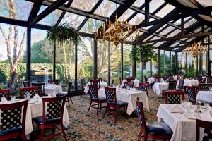 桑威奇丹韦伯斯特水疗酒店的餐厅配有白色的桌椅和吊灯