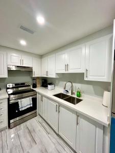 布兰普顿SUITE A 2 Bedroom Apartment的厨房配有白色橱柜和水槽