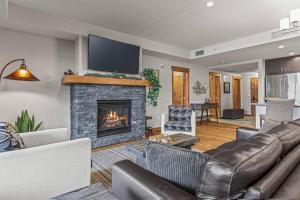坎莫尔Spring Creek Spacious Luxury & Views at White Spruce Lodge的带沙发和壁炉的客厅