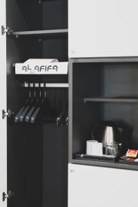 达喀尔Hôtel AL AFIFA的一间配备了黑白冰箱的小厨房