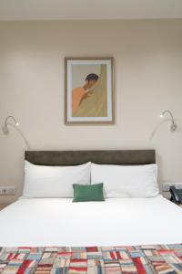 达喀尔Hôtel AL AFIFA的卧室配有带两盏灯的白色床